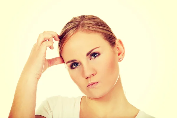 Nadenkend jonge vrouw haar hoofd krabben — Stockfoto