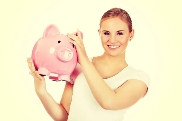 Feliz joven sosteniendo a Piggybank — Foto de Stock