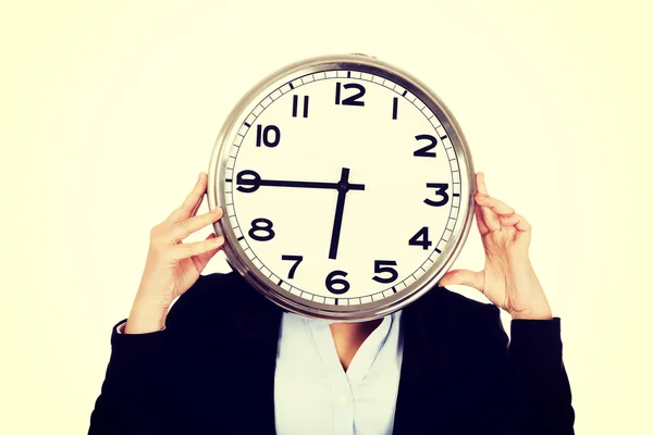 Mujer de negocios cubriendo la cara con un reloj — Foto de Stock