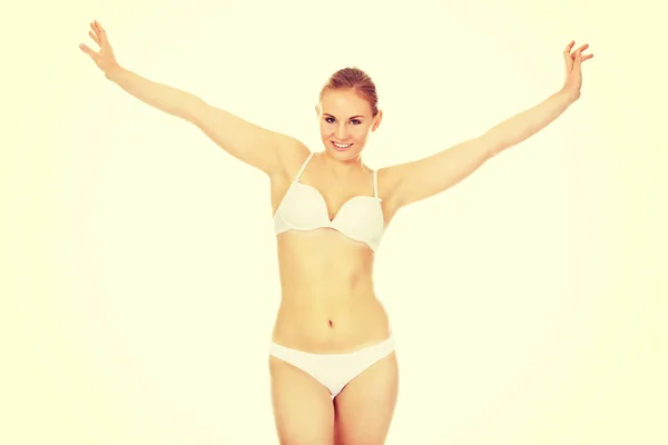 Happy young woman in white underwear holds her arms up — Stock Photo, Image