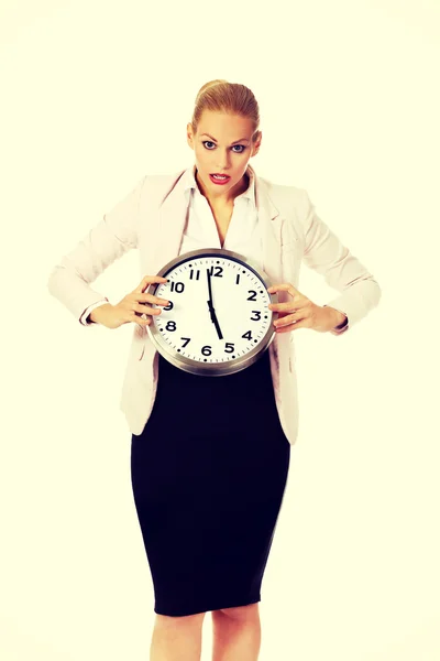 Shocked business woman holding office clock Stock Photo