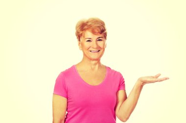 Gülümsemek yaşlı kadın bir şey açık avuç içinde sunulması