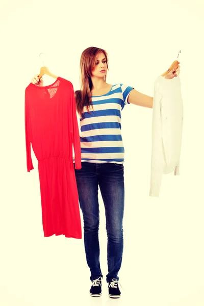 Teenage woman with two shirts thinking what to dress — Stock Photo, Image