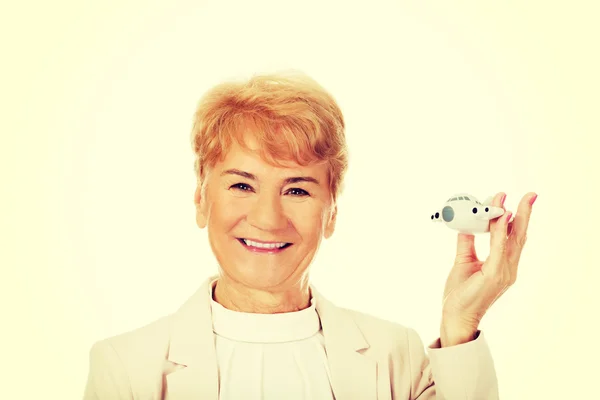 Sonrisa anciana elegante mujer sosteniendo un avión de juguete — Foto de Stock