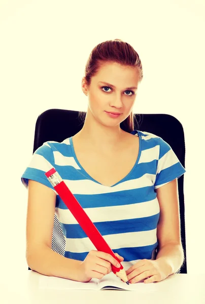 Teenager macht sich Notizen mit einem riesigen Stift — Stockfoto