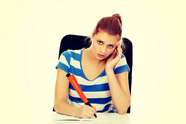 Mujer adolescente pensativa haciendo tarea — Foto de Stock