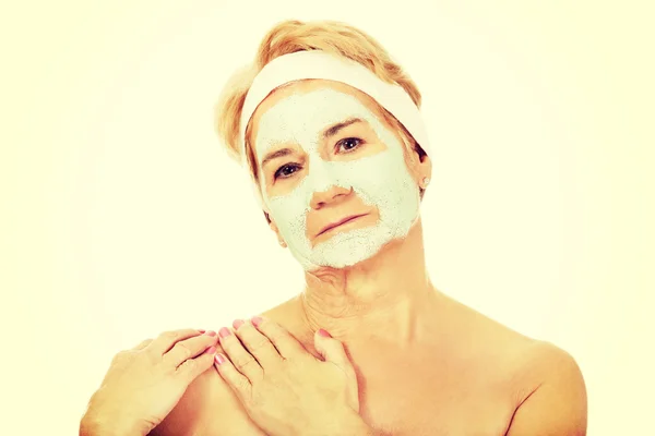 Relaxed elderly woman in facial mask — Stock Photo, Image