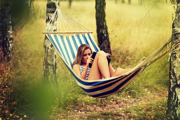 Young woman with tablet on the hammock — Stock Photo, Image