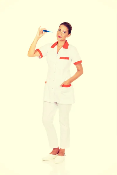 Молодая женщина-врач или медсестра держит термометр — стоковое фото