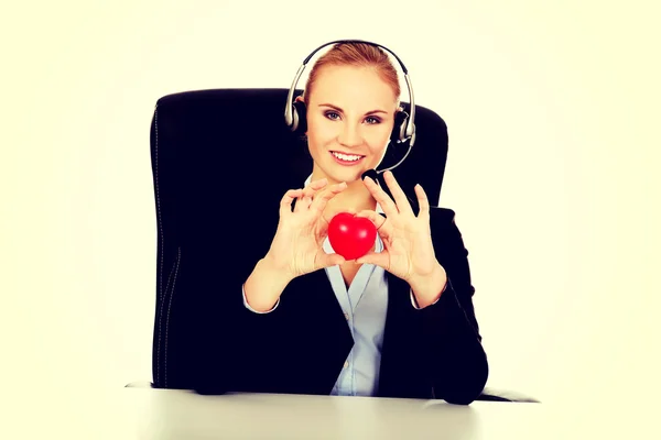 Feliz operador de teléfono mujer sosteniendo el juguete del corazón —  Fotos de Stock