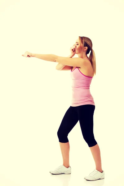 Jovem mulher em pose de fitness pontapé . — Fotografia de Stock