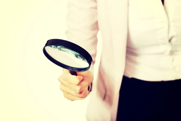 Young business woman using a magnifying glass — Stock Photo, Image