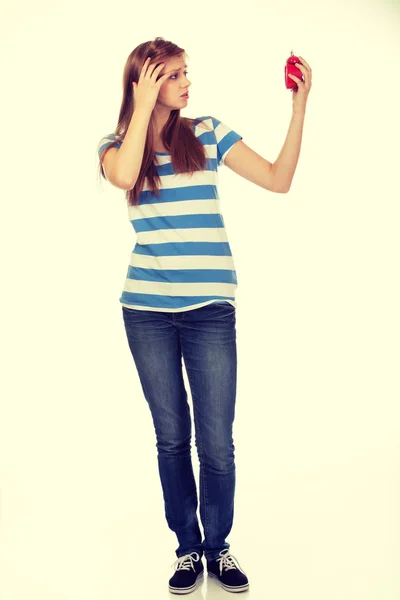 Shocked teenage woman with alarm clock — Stock Photo, Image