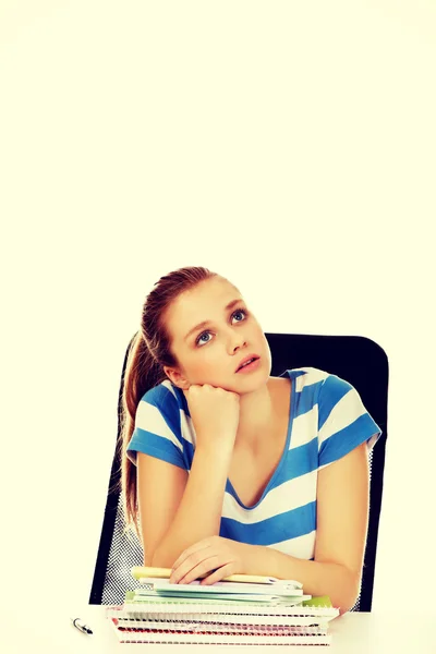 Mujer adolescente sentada detrás del escritorio y pensando — Foto de Stock
