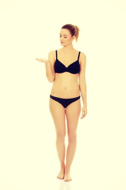 Mutlu kadın siyah iç çamaşırı bir şey açık avuç içinde sunulması