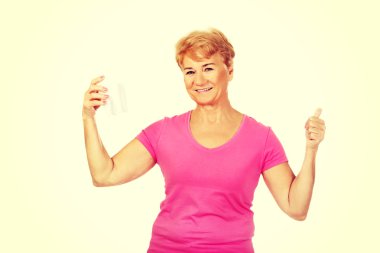 Bir diş model tutarak ve başparmak gösterilmesini gülümseyen kadın kıdemli