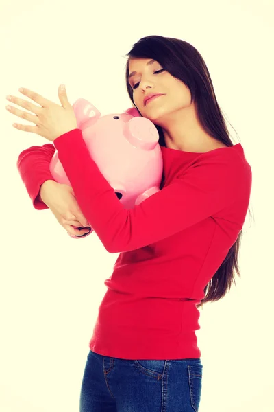 Glückliche junge Frau mit Sparschwein. — Stockfoto