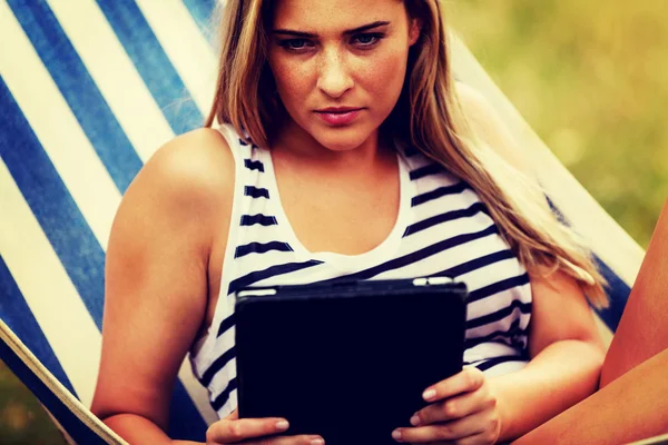 Mujer joven con la tableta en la hamaca —  Fotos de Stock