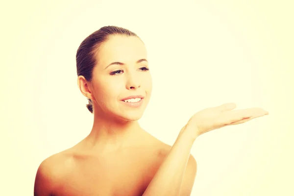 Nude woman with open hand showing space — Stock Photo, Image