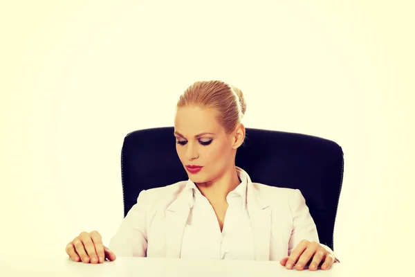 Young serious business woman sitting behind the desk — Stock Photo, Image