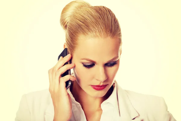 Mujer de negocios seria hablando a través de un teléfono móvil —  Fotos de Stock