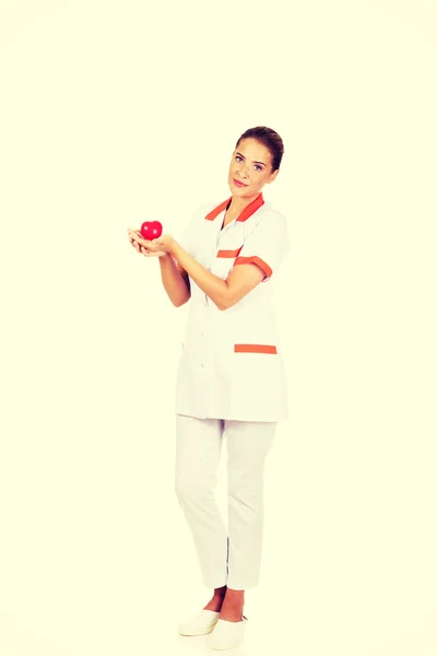 Молодая женщина-врач или медсестра с игрушечным сердцем — стоковое фото