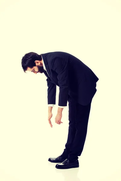 Joven hombre de negocios agachándose . — Foto de Stock