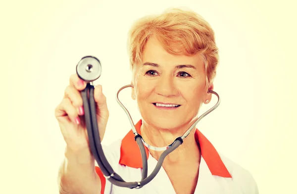 Glimlach oudere vrouwelijke arts holding stethoscoop — Stockfoto