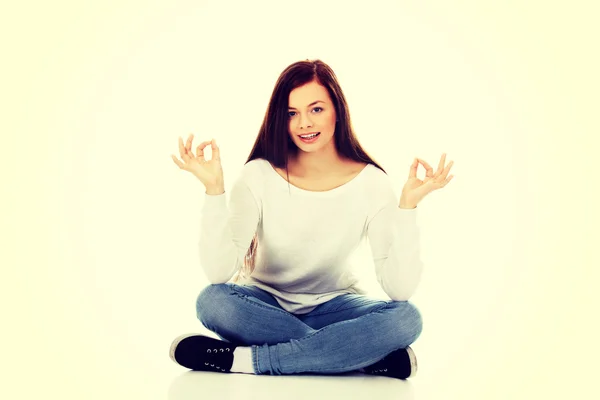 Joven estudiante sentada y haciendo yoga —  Fotos de Stock