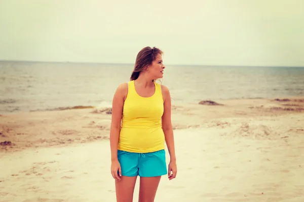 Donna stanca in piedi sulla spiaggia — Foto Stock