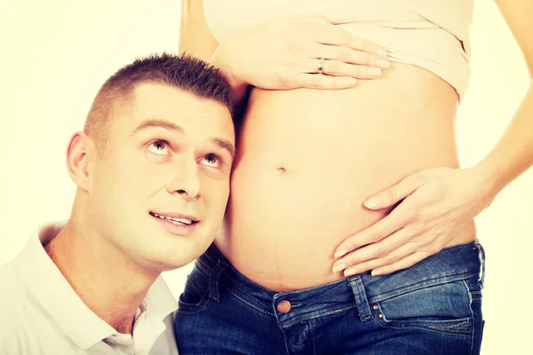 Vater hört Müttern zu, die schwanger sind — Stockfoto