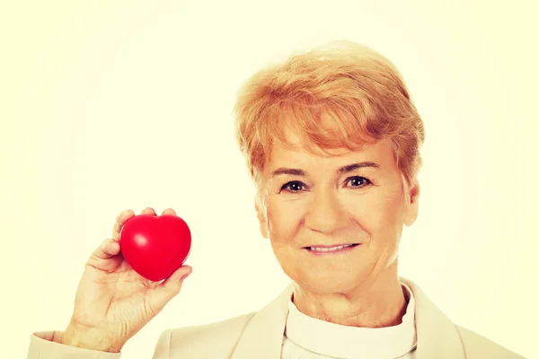 心臓モデルを保持している高齢者の女性を笑顔します。 — ストック写真