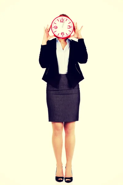 Business woman covering face with a clock — Stock Photo, Image