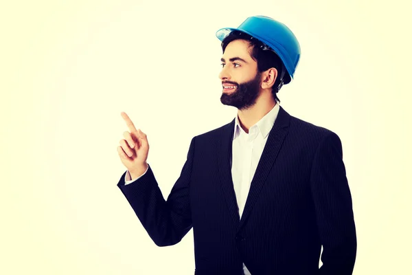 Ingeniero en casco protector apuntando hacia arriba . — Foto de Stock