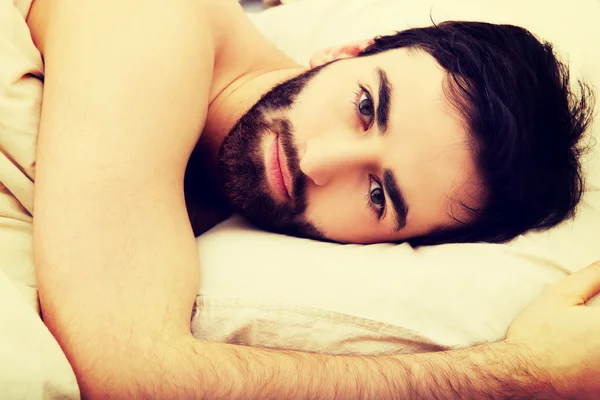 Mladý svalnatý muž ležící v posteli. — Stock fotografie