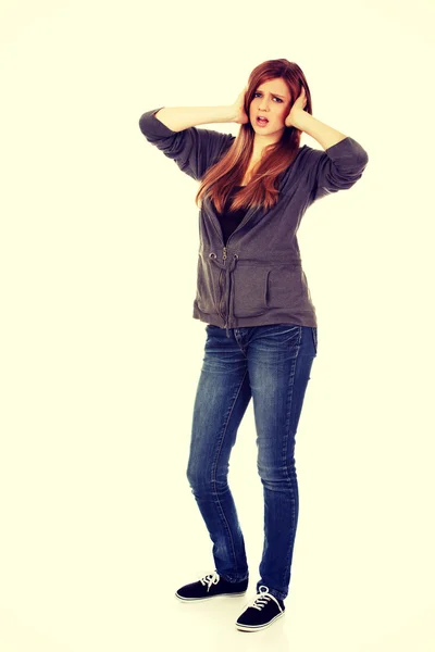 Angry teenage woman covering ears with hands — Stock Photo, Image