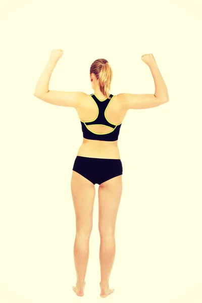 Vista posteriore della donna atletica che mostra i muscoli — Foto Stock