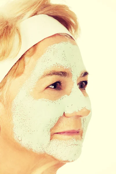 Relaxed elderly woman in facial mask