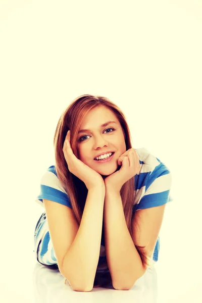 Smiling teenage woman lying on floor — Stock Photo, Image