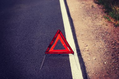 bir yol üzerinde kırmızı bir uyarı üçgeni