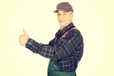 Başparmak yukarıya ile üniformalı olgun bahçıvan