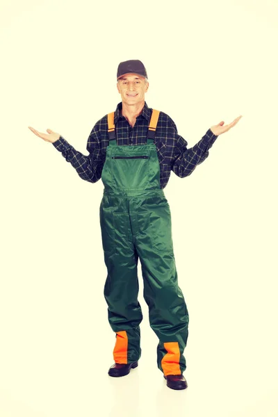 Gardener in uniform showing space with both hands — Stock Photo, Image