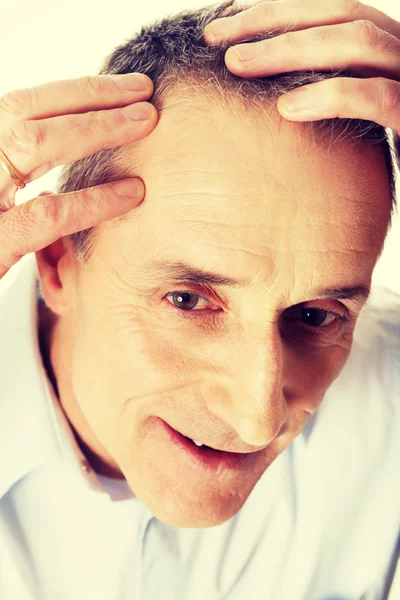 Uomo esaminando i suoi capelli — Foto Stock