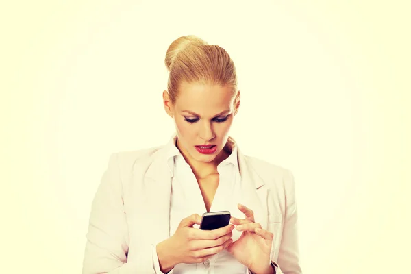 Junge Geschäftsfrau mit einem Mobiltelefon — Stockfoto