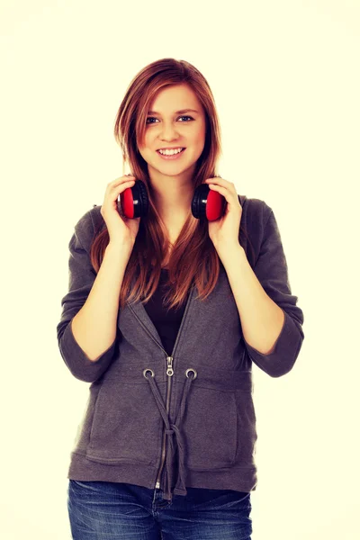 Mujer adolescente sosteniendo auriculares rojos —  Fotos de Stock