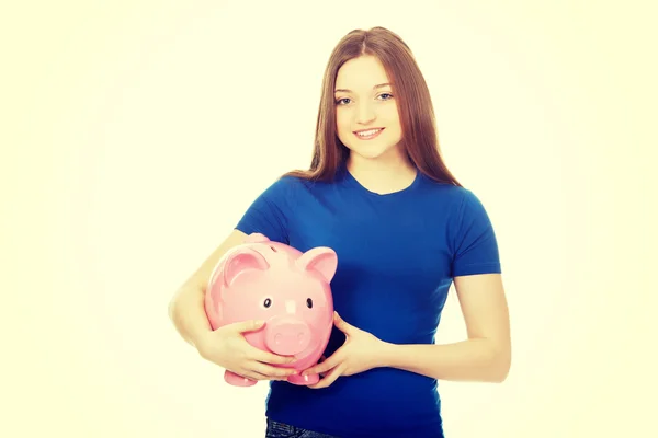 Tizenéves nő gazdaság piggybank. — Stock Fotó