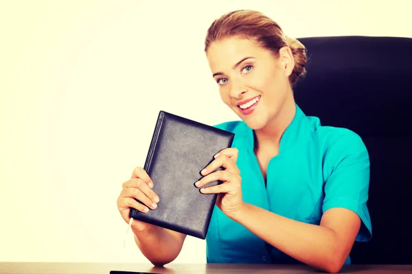 Mladý ženský lékař nebo sestra ukazuje notebook — Stock fotografie