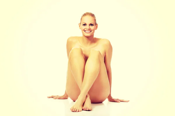 Lächeln nackte Frau sitzt auf dem Boden — Stockfoto