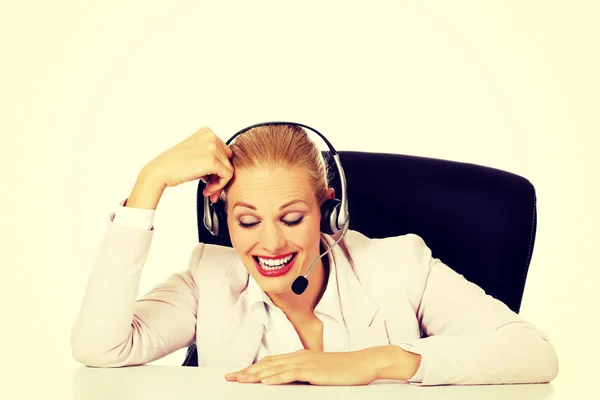 Uśmiech infolinia operatora siedzi za biurkiem i mówienie przez słuchawki — Zdjęcie stockowe
