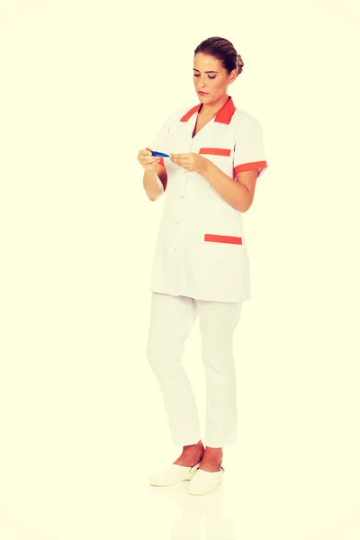 Young female doctor or nurse holding thermometer — Stock Photo, Image